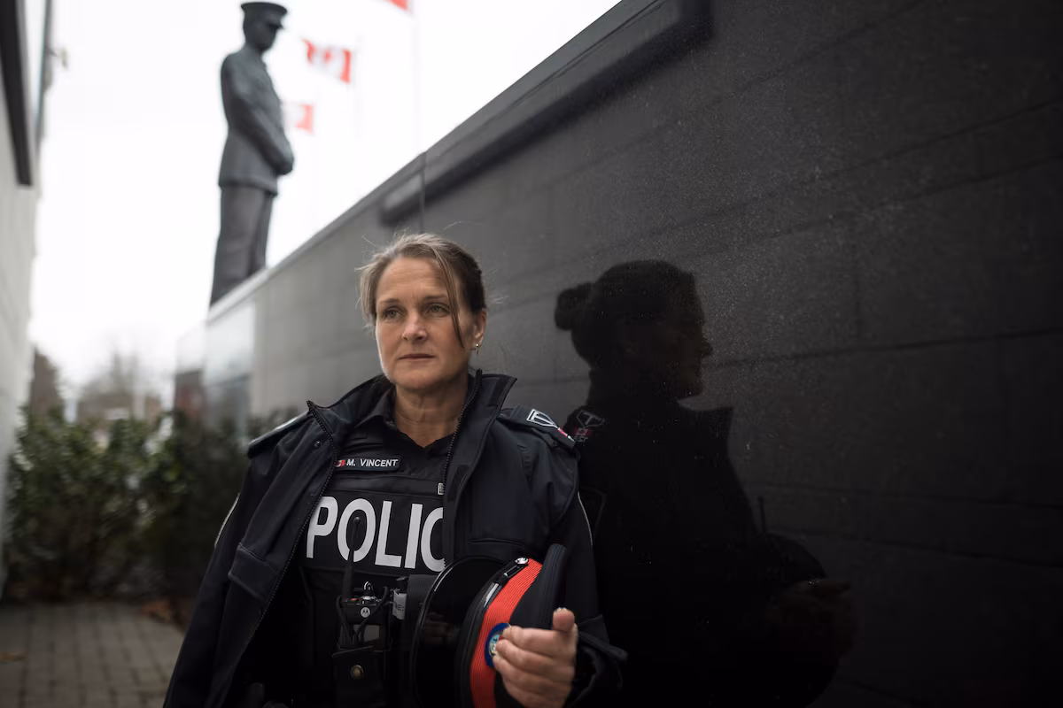 Michelle Vincent in police uniform beside a police memorial, photographed for The Globe and Mail